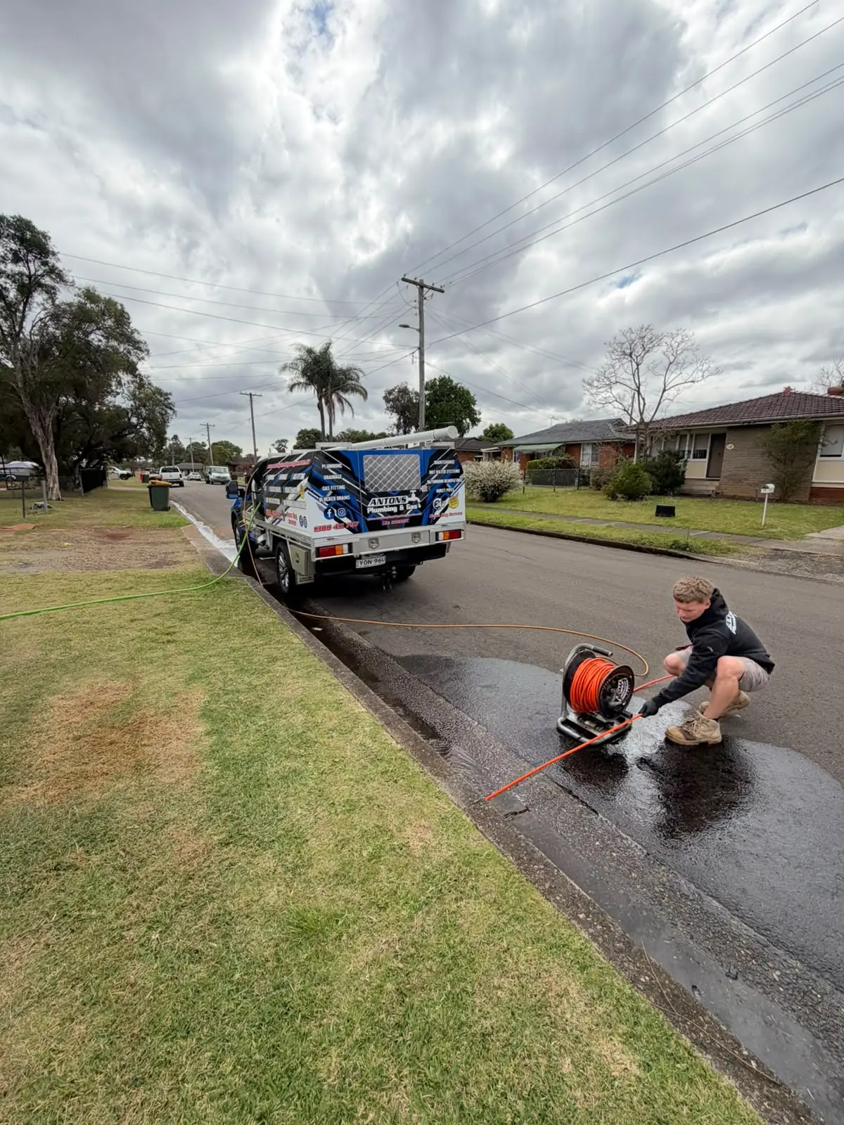 Drain-clearing equipment being used beside a Northern Beaches street