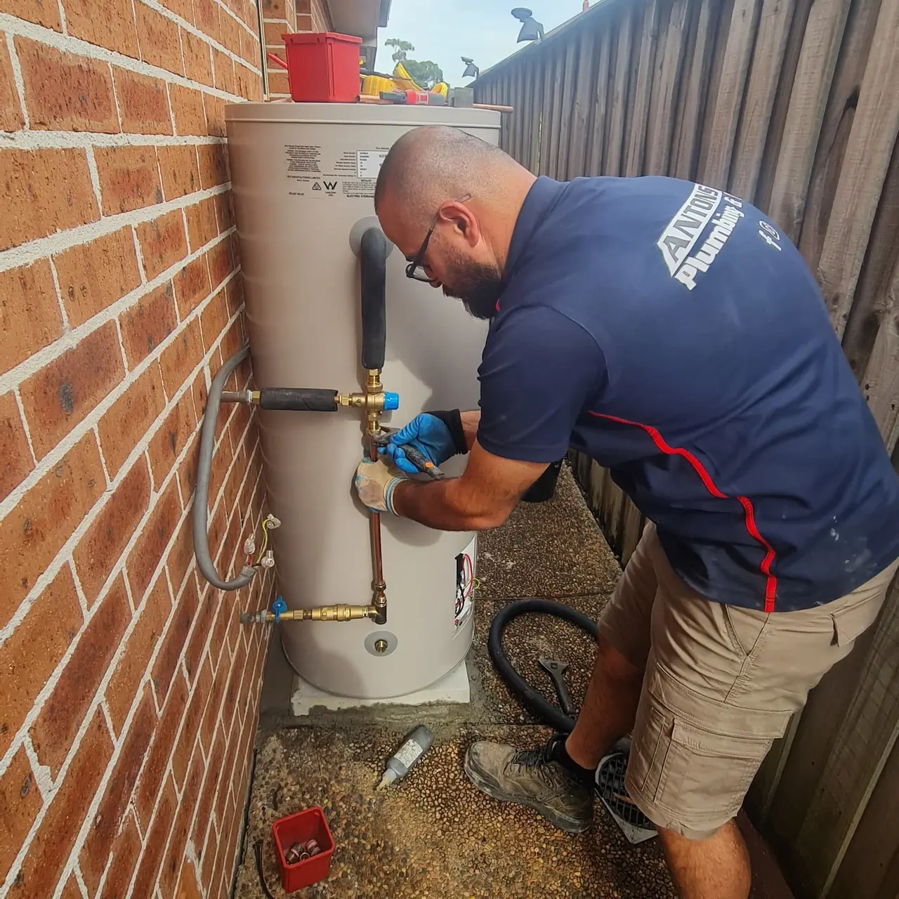 Antons plumber repairing pipework on an outdoor hot-water system