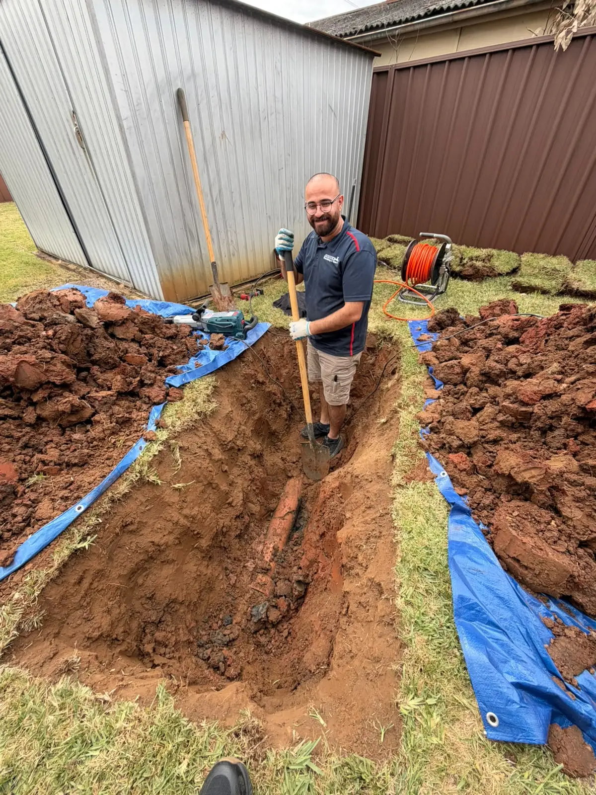 Antons plumber standing in a trench during pipework repairs